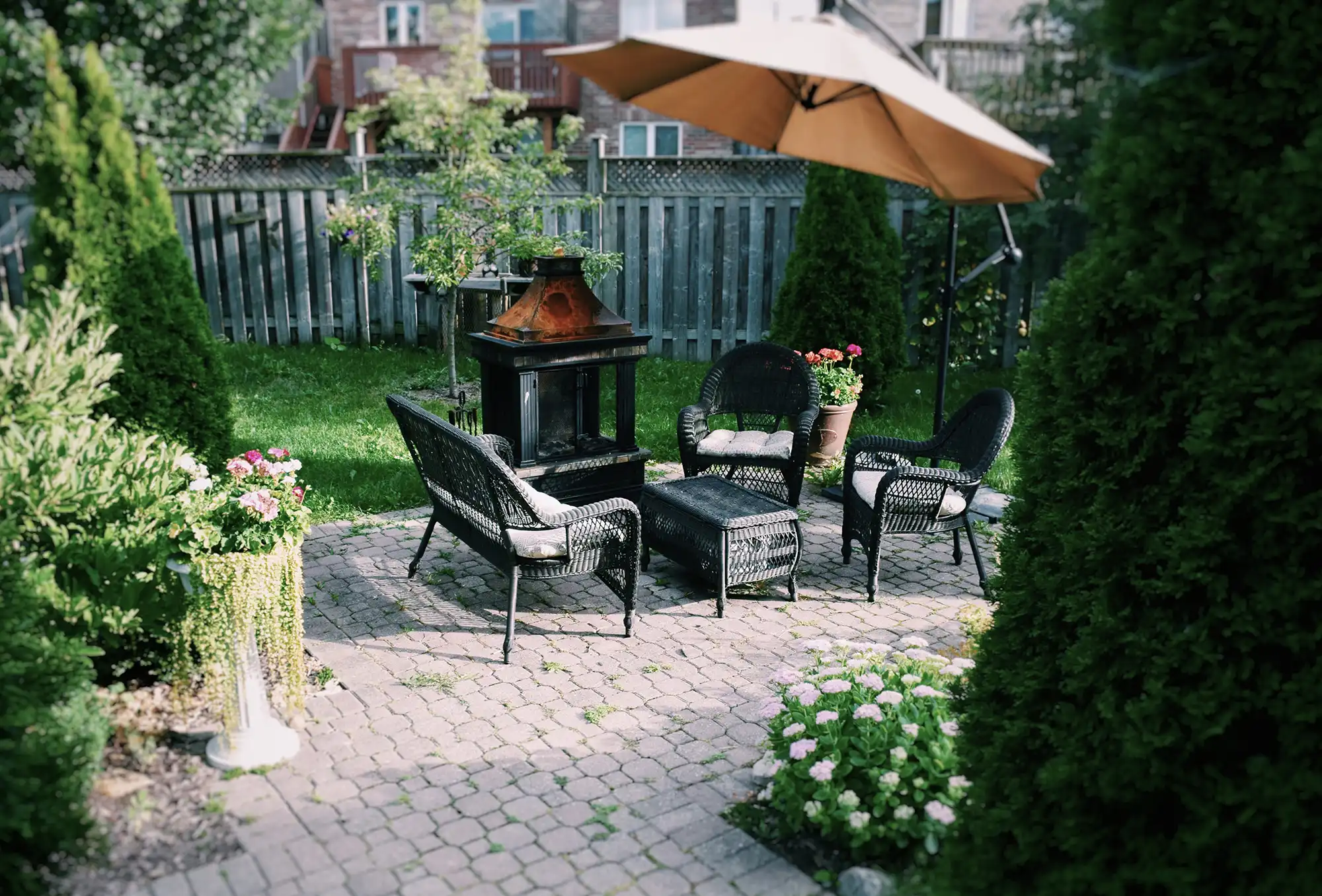 Clean residential backyard patio with outdoor furniture and landscaping